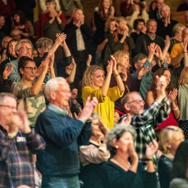 yellow jumper lady clapping audience